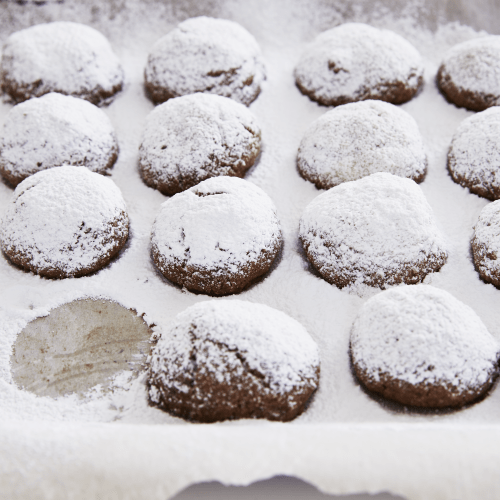 Pecan cocoa puffs on pan with dusting of icing sugar